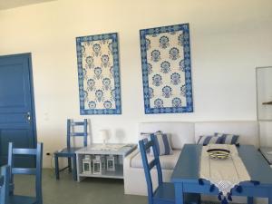 a living room with blue chairs and a table and a couch at casa koklakura in Leipsoi