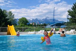 a young girl in the water at a swimming pool at Aqualand Penzion - free parking in Poprad