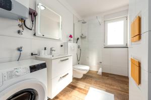 a white bathroom with a toilet and a sink at Villa Mare e Monti in Nin +18 photos