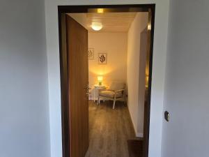 a hallway with a chair and a table in a room at Wohnen auf dem Lande in Wiemersdorf