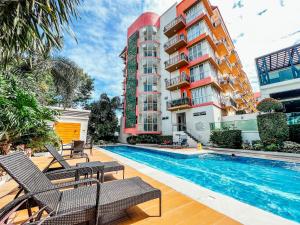 a hotel with a swimming pool in front of a building at Modern Studion with 2 Queen Bed in Sampong