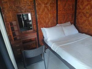 a small bed and a chair in a room at Enchanted River Rock Island Resort in Hinatuan