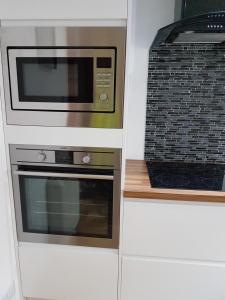 a microwave and a toaster oven in a kitchen at Langley Apartment in Inverness