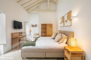 a bedroom with a large bed and a tv at Alma da Vida Ferragudo in Ferragudo