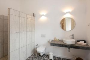 a bathroom with a toilet and a sink and a mirror at Alma da Vida Ferragudo in Ferragudo