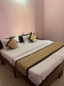 a large bed with black and white pillows on it at Hotel Mahadev Home-Stay !! Near Chandigarh It'l Airport in Chandigarh Airport