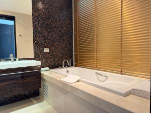 a bathroom with a large tub and a sink at The 211 Rayong in Ban Phlong Sawai +24 photos