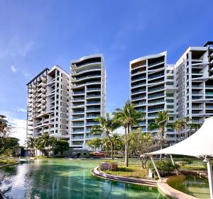 two tall buildings and a body of water with palm trees at The 211 Rayong in Ban Phlong Sawai