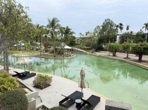 a large swimming pool with chairs and trees at The 211 Rayong in Ban Phlong Sawai
