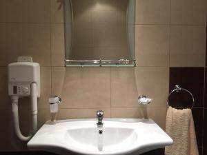 Un lavabo blanco en un baño con espejo. en GM Royal Plaza, en Borovets 6 fotos más
