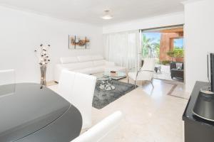 a living room with a white couch and a table at Bahia de los Menceyes Heated Pools in Palm-Mar