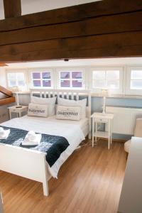 a bedroom with a white bed and some windows at Sophienhof in Bad Berka