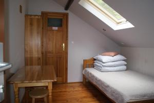 a bedroom with a bed and a table and a window at Dom w Kwiatach in Ojców
