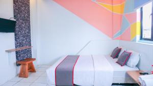 a bedroom with a bed and a colorful wall at Artemis Hotel Bekasi in Cikunir Satu