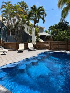 a large blue pool with two chairs and palm trees at Ilot Bleu in Boucan Canot