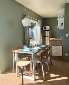 a dining room with a table and chairs in a kitchen at Somo Bungalow Resort - Camping Latas in Somo