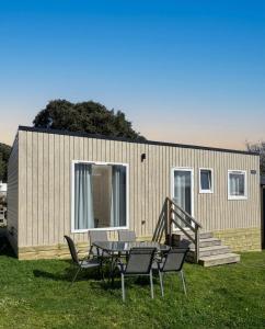 a tiny house with a table and chairs in the yard at Somo Bungalow Resort - Camping Latas in Somo
