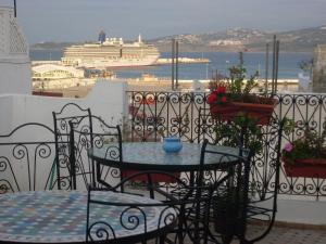 a table and chairs on a balcony with a cruise ship at The Medina Hostel in Tangier