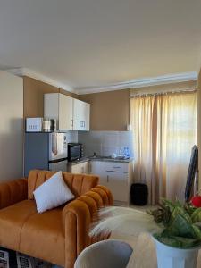 a living room with a couch and a kitchen at Zambata Self Catering in Gqeberha
