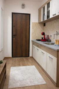 a kitchen with a wooden door and a counter at Apartman48Brzeće in Brzeće