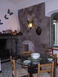a dining room with a stone fireplace with a table and chairs at Villa Brigio in Forio d'Ischia