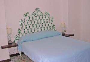 a bedroom with a bed with a blue bedspread at Villa Brigio in Forio d'Ischia