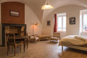 a bedroom with a bed and a table and chairs at le clos de la monne in Saint-Amant-Tallende