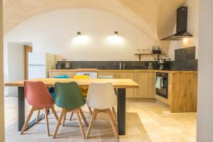 a kitchen with a wooden table and four chairs at le clos de la monne in Saint-Amant-Tallende