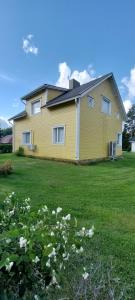 a yellow house with white flowers in the yard at Omakotitalo Pirintie 22, Härmä in Kauhava