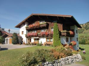 une grande maison avec des fleurs sur les balcons dans l'établissement Schattwalder Hof, à Schattwald