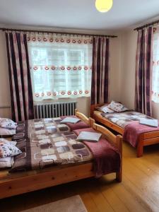a bedroom with two beds and a window at Sielankowy Domek in Istebna