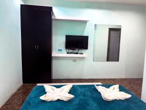 a room with two white pillows on a bed with a television at The JRJF Hotel near Tagum Terminal in Tagum +41 photos
