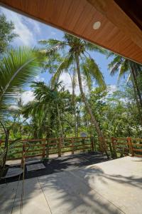 a view from the porch of a house with palm trees at Pam's Cabin Batukaras in Batukaras