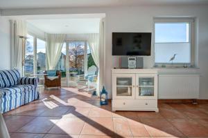 a living room with a blue couch and a tv at Haus Meerblick - 14 in Ahlbeck