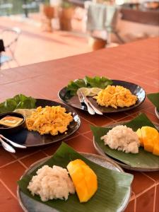 three plates of food sitting on a table at Sunin Hotel Dondet Riverside in Don Det +73 photos
