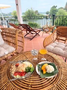 a wicker table with two plates of food on it at Sunin Hotel Dondet Riverside in Don Det
