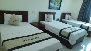 a hotel room with two beds with white sheets at Nhà Khách CF15 in Danang