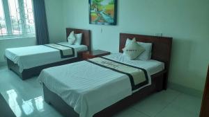 a hotel room with two beds in a room at Nhà Khách CF15 in Danang
