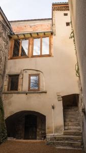 a building with stairs leading up to a building with windows at le clos de la monne in Saint-Amant-Tallende