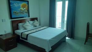 a bedroom with a bed and a large window at Nhà Khách CF15 in Danang