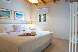 a bedroom with a bed with a tray of food on it at Villa Avlaki in Vlikhón +21 photos