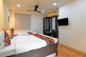 a bedroom with a bed and a flat screen tv at FabHotel Demattrie Budget in Kolkata