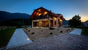 a log home with a lit up facade at dusk at Villa D-Ika by Villas Guide in Brušane
