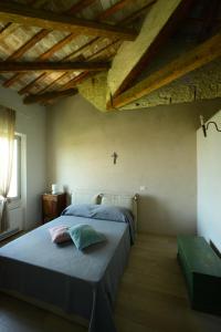 una camera da letto con un letto con una croce sul soffitto di La Foresteria del Convento a SantʼArcangelo di Romagna