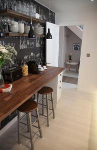 cocina con encimera de madera y taburetes en Albero Apartment, en Eyemouth