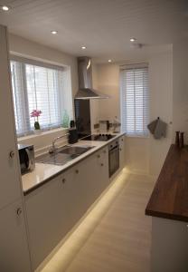 a large kitchen with a sink and a stove at Albero Apartment in Eyemouth