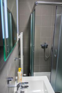 a bathroom with a sink and a shower with a mirror at Apartments Petrova170 in Zagreb +24 photos