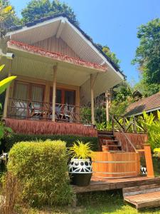 a house with a porch and stairs to it at Tolani Resort Koh Kood in Ko Kood