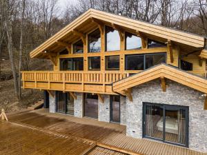 a large wooden house with a wrap around deck at A Páholy - Grand Chalet Mátra in Mátraszentimre