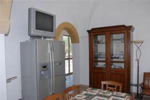 uma cozinha com uma televisão em cima de um frigorífico em Villa Rita Bed & Breakfast em Campi Salentina